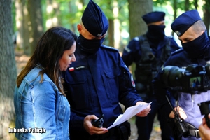 policjanci i kobieta podczas poszukiwań w lesie