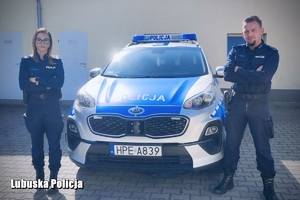 policjanci stoją przy radiowozie