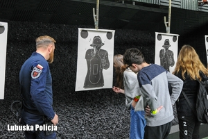 Policjant z uczniami na strzelnicy