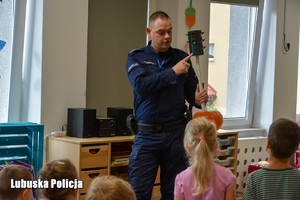 Policjant pokazuję dzieciom symulator sygnalizacji świetlnej