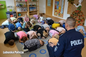 Policjant prowadzi scenę symulacyjną wraz z dziećmi