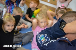 Policjant prowadzi scenę symulacyjną wraz z dziećmi