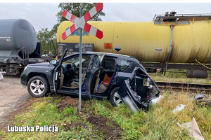 Samochód osobowy stoi na poboczu po uderzeniu przez pociąg