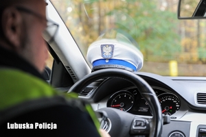 Czapka policjanta na desce rozdzielczej pojazdu