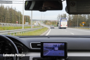 Widok z policyjnego radiowozu na pojazd poruszający się po drodze ekspresowej