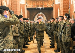 Poczet sztandarowy wojska wchodzi do kościoła.
