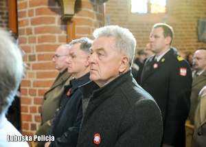 Wicewojewoda Lubuski z innymi osobami uczestniczy we mszy świętej w kościele.