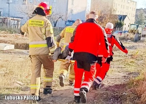 Strażacy i ratownicy medyczni podczas udzielania pomocy osobie bezdomnej.