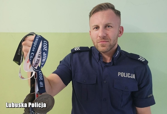 policjant trzyma medale