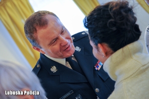 Komendant Wojewódzki Policji składa życzenia świąteczne kobiecie.