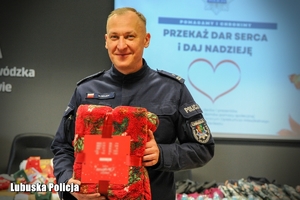Policjant podczas pakowania prezentów świątecznych.