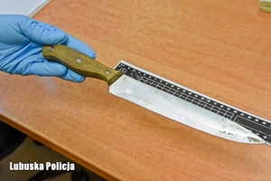 Policjant dokonuje oględzin noża, który został użyty do rozboju