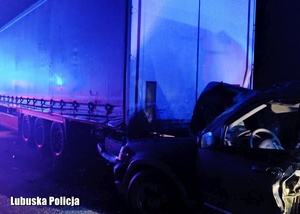 Uszkodzony pojazd osobowy oraz uszkodzona naczepa ciężarówki.