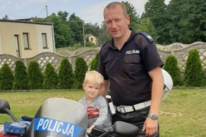 Policjant wraz z dzieckiem przy motocyklu