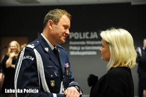 policjant odbiera gratulacje od kobiety