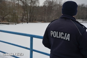 policjant obserwuje zamarznięte jezioro