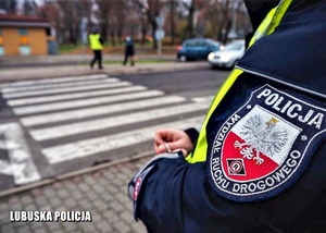 policjant stoi przy przejściu dla pieszych