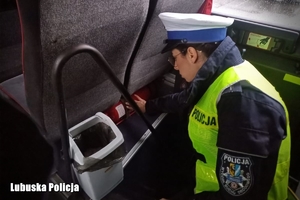 policjantka spogląda na gaśnicę w autokarze