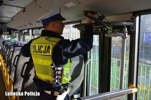 policjant kontroluje drzwi autokaru