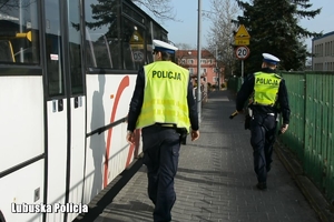 policjanci idą wzdłuż autokaru