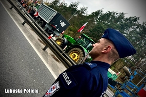 policjant obserwuje protestujących rolników
