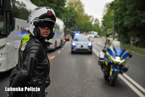 policjantka w stroju motocyklisty stoi na drodze