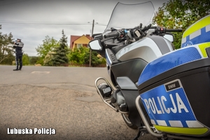 Policyjny motocykl, w tle widoczny policjant