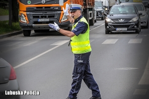 Policjant ruchu drogowego kieruje ruchem
