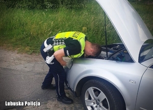 policjant wymienia żarówkę w pojeździe