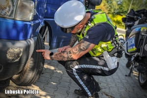 policjant kontroluje ogumienie pojazdu