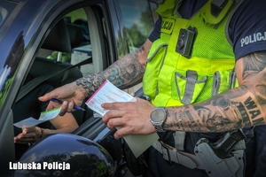 policjant wręcza mandat kierowcy