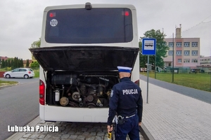 Policjant kontroluje stan techniczny autokaru