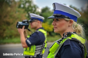 Policjant i policjantka ruchu drogowego z miernikiem prędkości