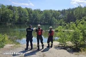 policjant i strażacy nad wodą