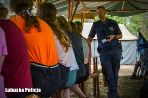 policjant rozmawia z dziećmi na kolonii