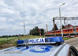 Policyjny radiowóz w tle widoczny pociąg