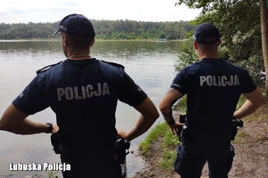 policjanci spoglądają na jezioro