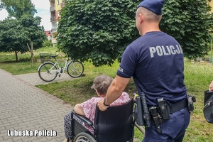 policjant prowadzi osobę na wózku