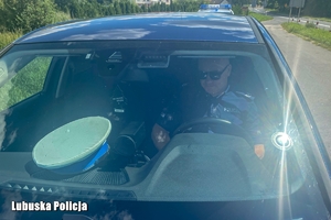 Policjant przy urządzeniu kontrolnym na podszybiu pojazdu