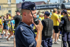 Policjant podaje komunikat przez radiostację