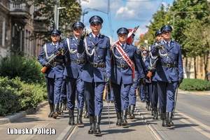 Kompania honorowa policjantów idzie ulicą