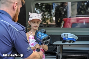Policjant dający dziecku urządzenie kontrolne