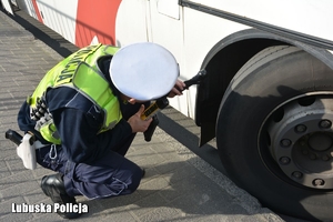 Policjant sprawdza stan opon autokaru