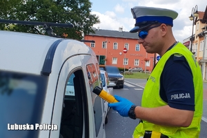 Policjant ruchu drogowego przy badaniu trzeźwości kierowcy