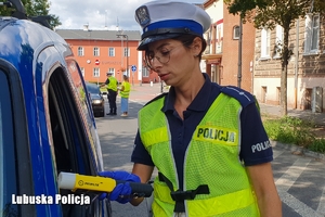 Policjantka ruchu drogowego przy badaniu trzeźwości kierowcy