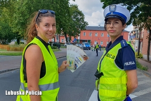 Kobieta trzymająca broszury informacyjne z policjantką ruchu drogowego