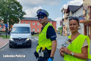 Kobieta trzymająca broszury informacyjne z policjantem ruchu drogowego