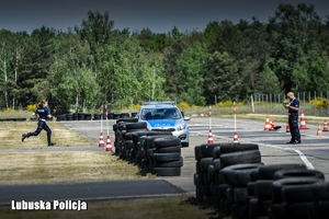 Policjanci i radiowóz na placu manewrowym