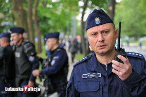 Policjant podaje informacje przez radiostację