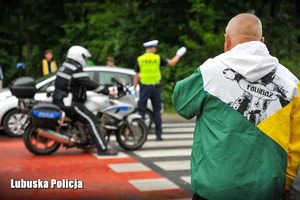 Kibic obserwuje policjantów na drodze